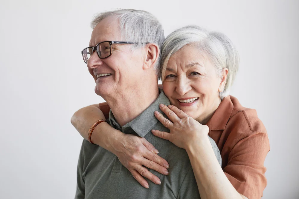 Pareja de adultos mayores sonrientes porque cuentan con planes funerarios